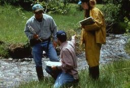 Researchers talking next to a river